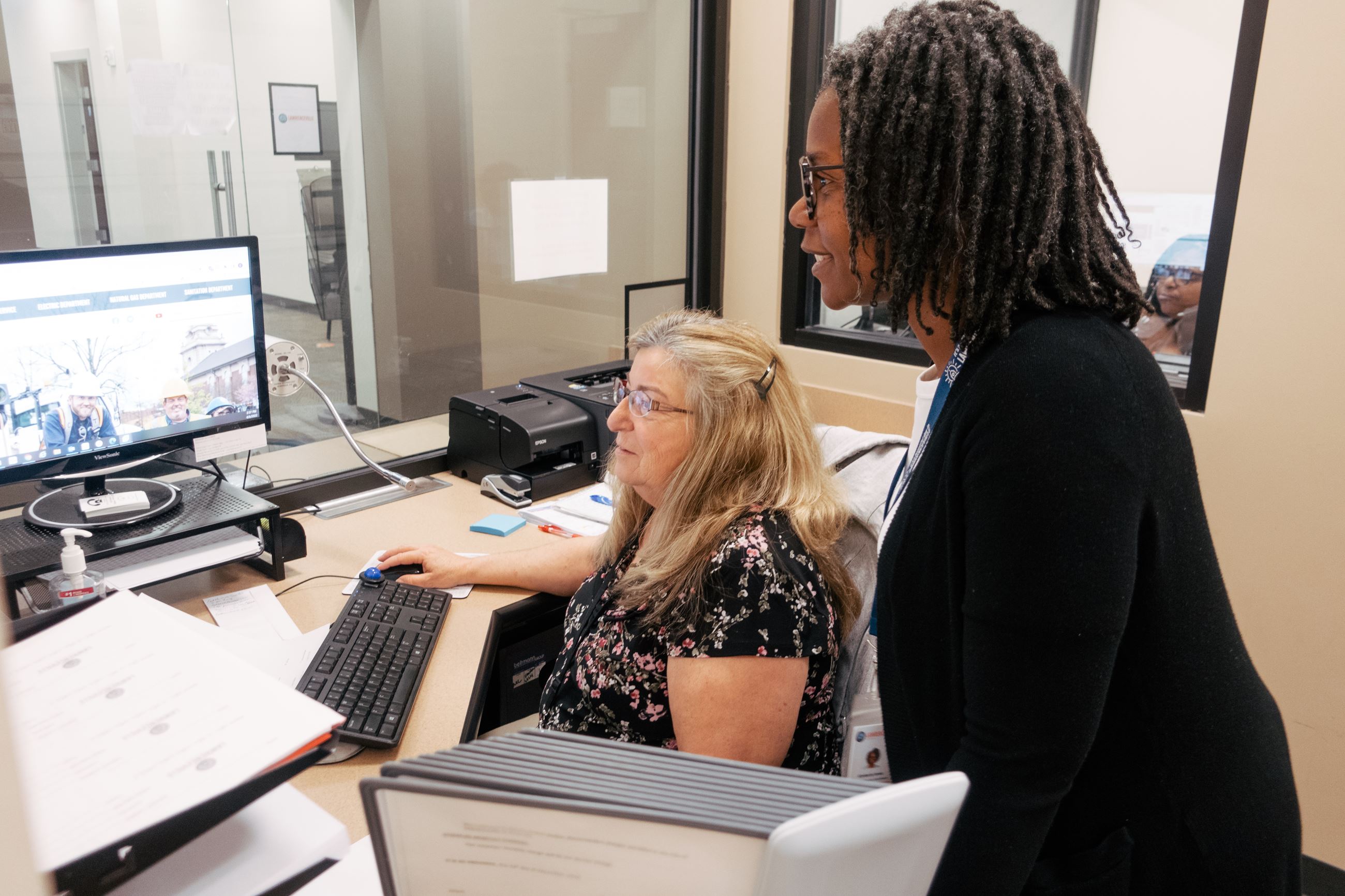 Women assisting employee at computer